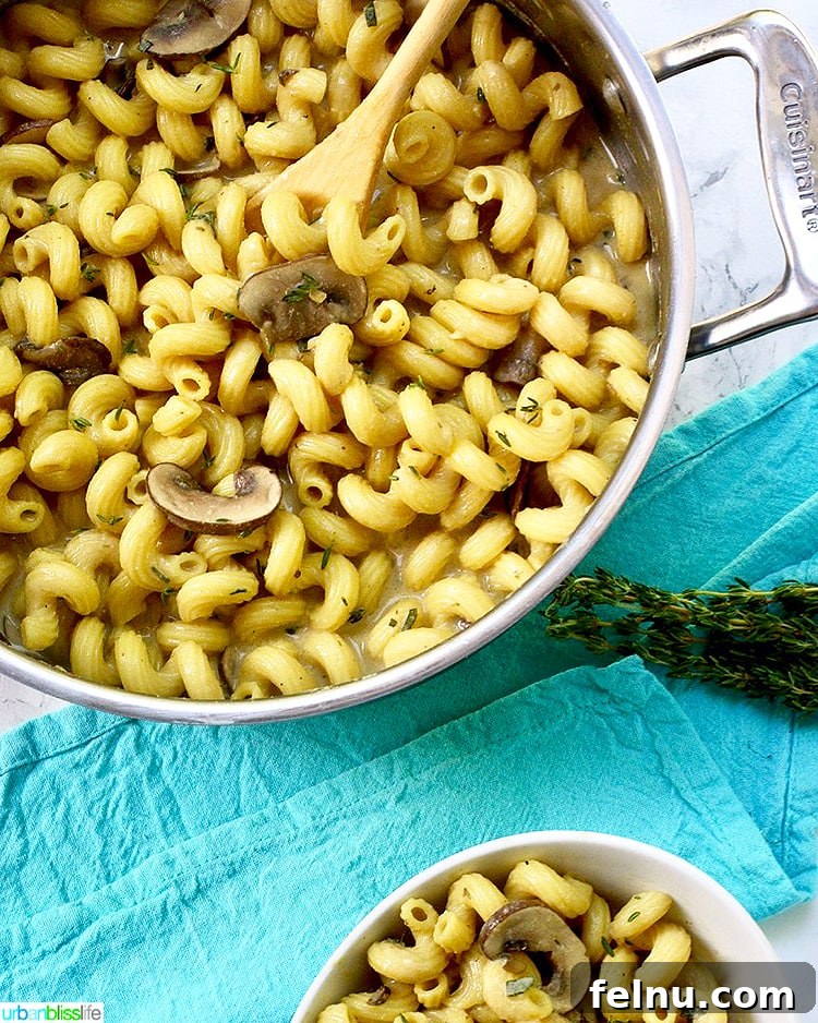 Dreamy Vegan Mushroom Pasta 4 Overhead shot of Creamy Vegan Mushroom Pasta in a bowl on a wooden surface.
