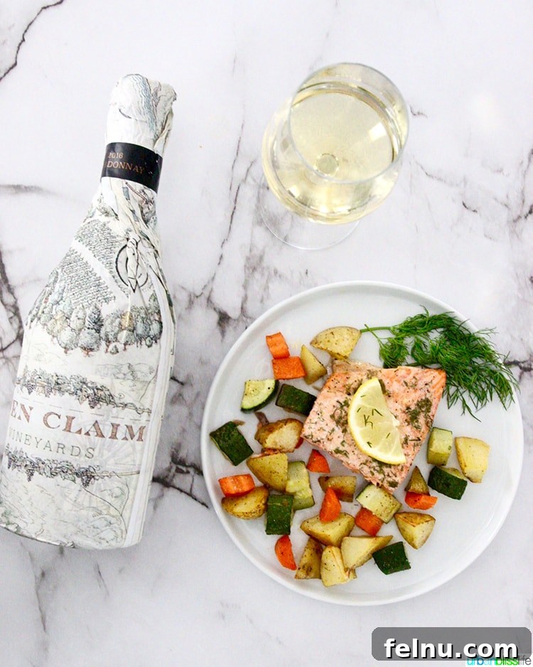 Effortless Oven Baked Salmon and Veggies 7 Sheet Pan Salmon with vegetables, a glass of white wine, and a bottle of Open Claim Vineyards Chardonnay.