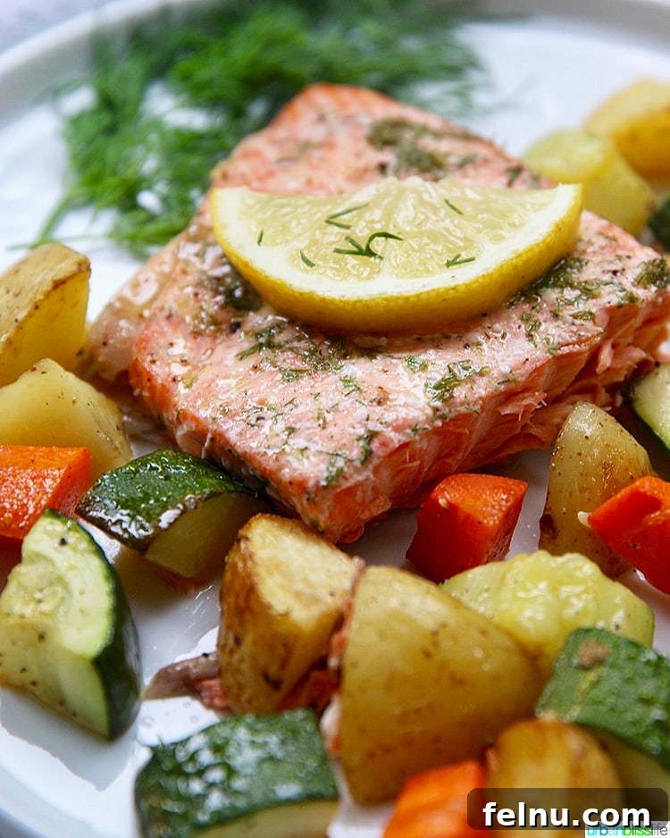 Effortless Oven Baked Salmon and Veggies 8 Sheet Pan Salmon with vegetables, plated and garnished with fresh dill.