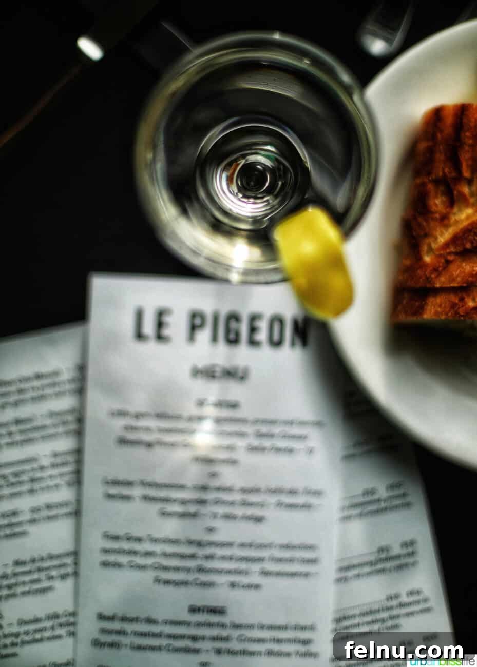 Celebrate in Style: Portland's Finest Restaurants 41 A cocktail and elegant menu at Le Pigeon restaurant in Portland, Oregon, setting a refined dining mood.