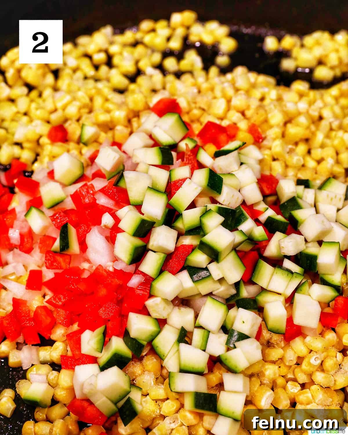 Creamy Kaleidoscope Corn 7 chopped zucchini, red bell peppers, and corn cooking in a large skillet.