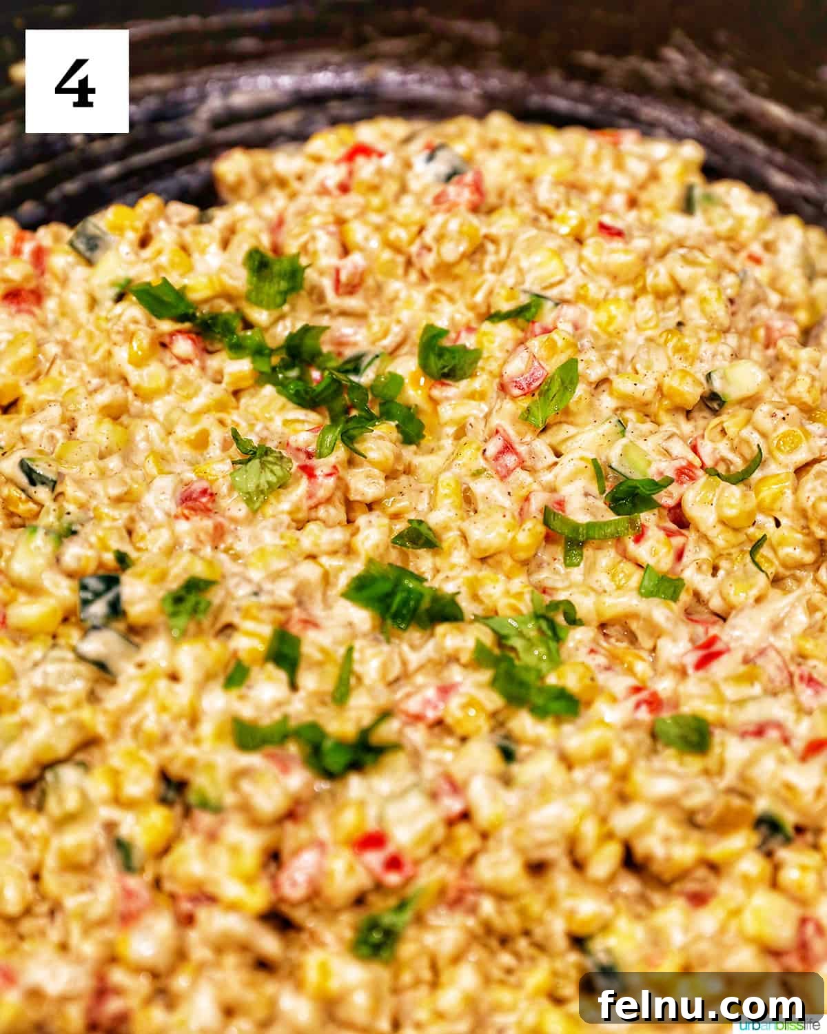 Creamy Kaleidoscope Corn 9 mixed cream cheese confetti corn with green onions in a large skillet.