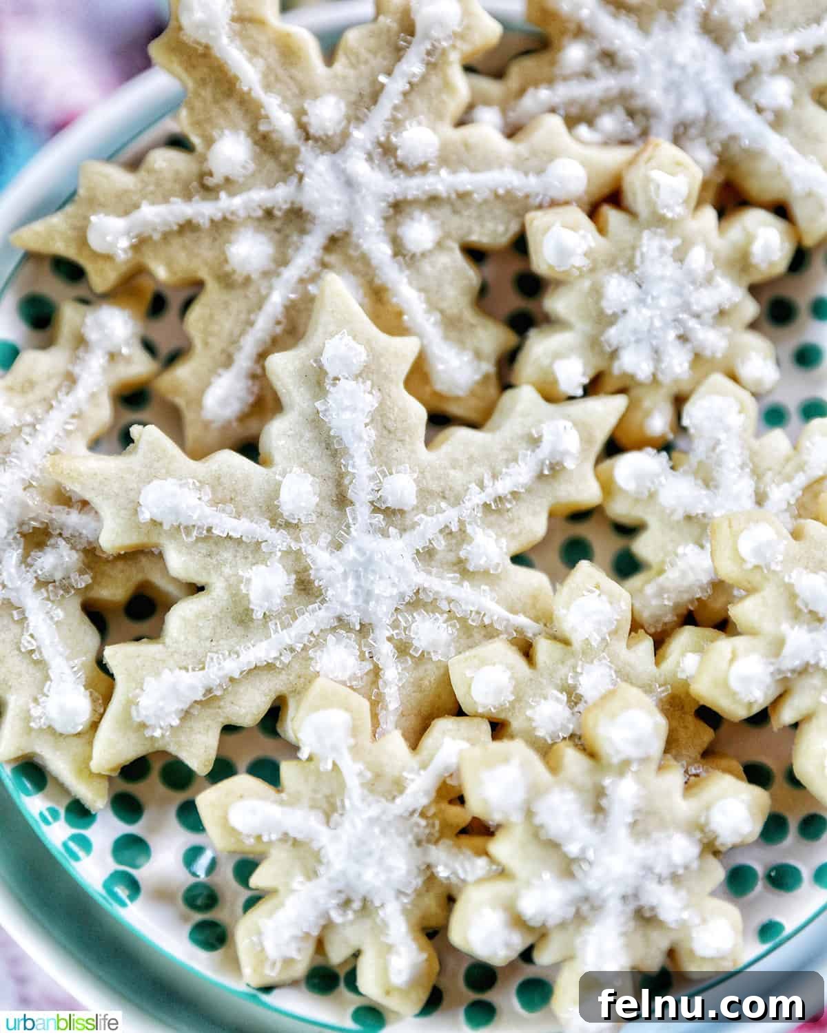 Bake Ahead Bliss: Delicious Christmas Cookies for Your Freezer 5 plate full of snowflake sugar cookies decorated with royal icing and decorator sugar.