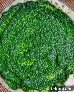 Emerald Ocean Pizza 8 spinach pesto being spread on pizza dough