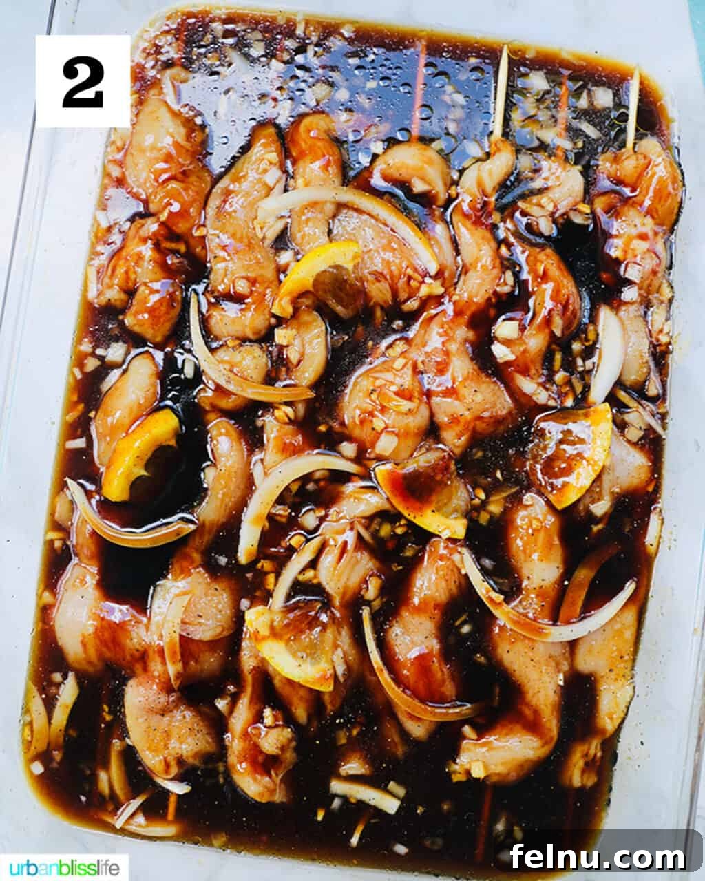 Honey Garlic Chicken Kebabs 5 Raw Chicken Skewers Marinating in a Large Glass Dish