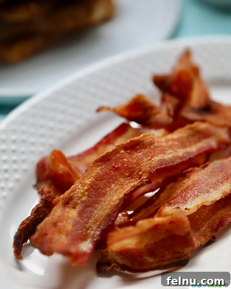 Ultimate Air Fryer Bacon 5 Closeup of crispy air fryer bacon on a cutting board
