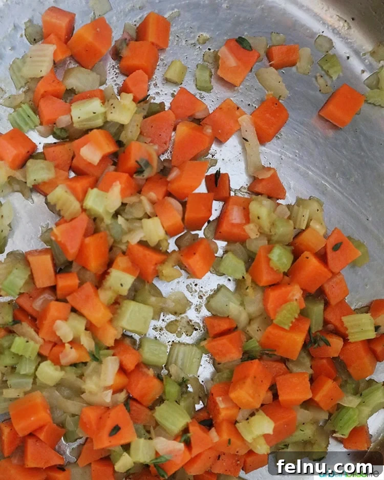 Sautéing carrots, celery, and onions in a pot to create a flavorful base for the chicken soup.