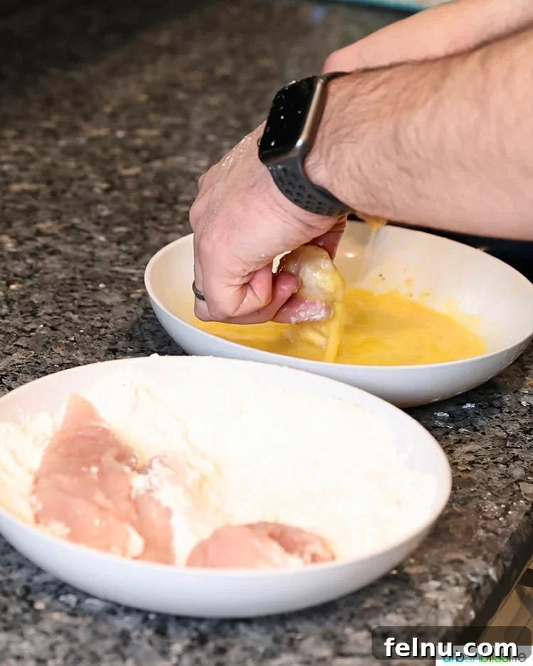 Dipping chicken tenders in egg wash