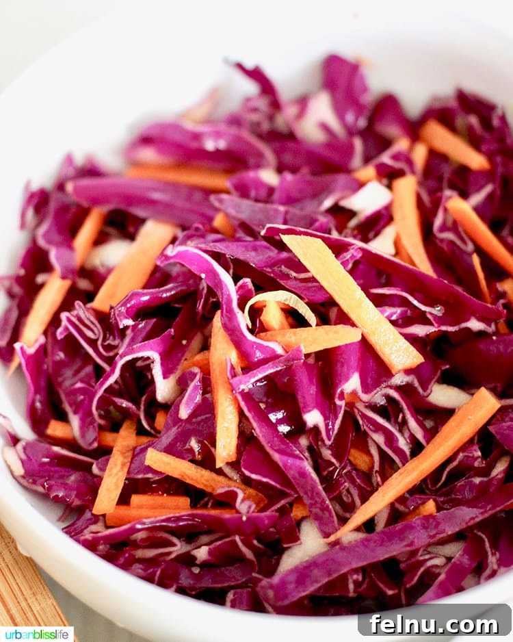 Red cabbage and carrot slaw being prepared for tacos