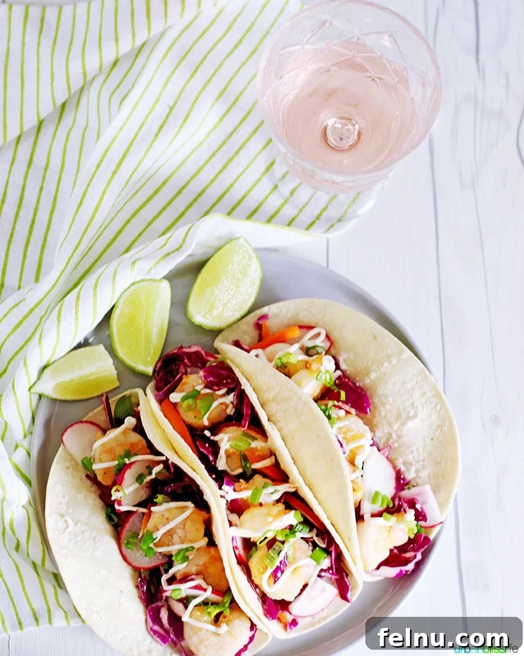 Three shrimp tacos served with a glass of light-bodied rosé wine