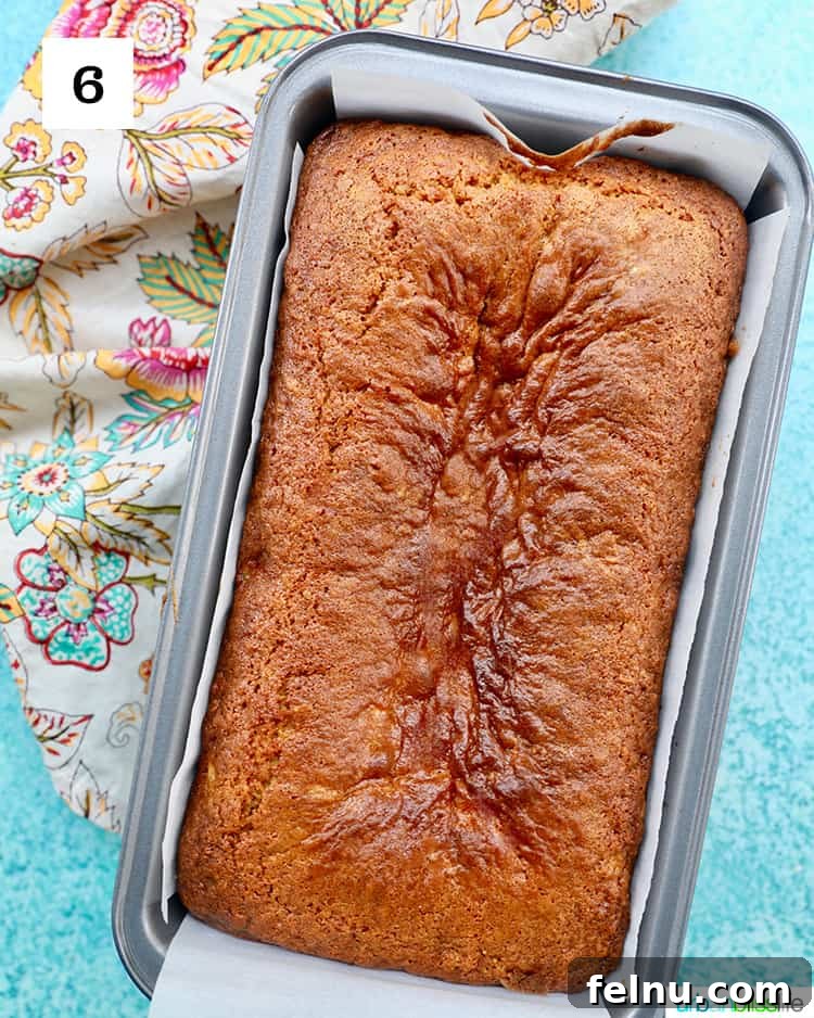 Pineapple Loaf 11 pineapple bread freshly baked in a loaf pan on blue background with a colorful floral napkin.