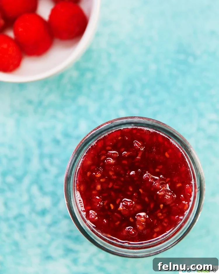 Raspberry jam in a jar with raspberries