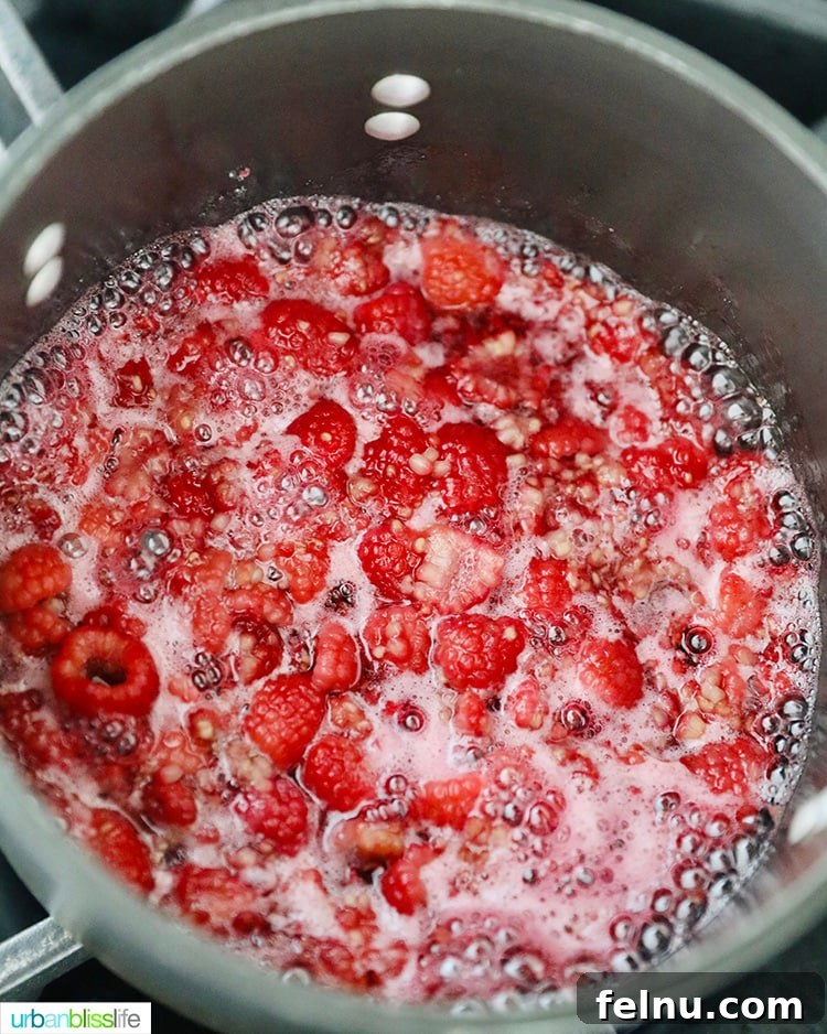 Raspberry jam cooking on stovetop
