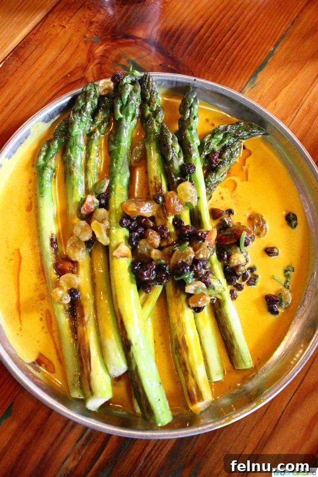 Bollywood Extravaganza 5 Plate of perfectly grilled asparagus in a creamy green garlic and turmeric curry with a raisin, almond, and currant chutney at Bollywood Theater Portland