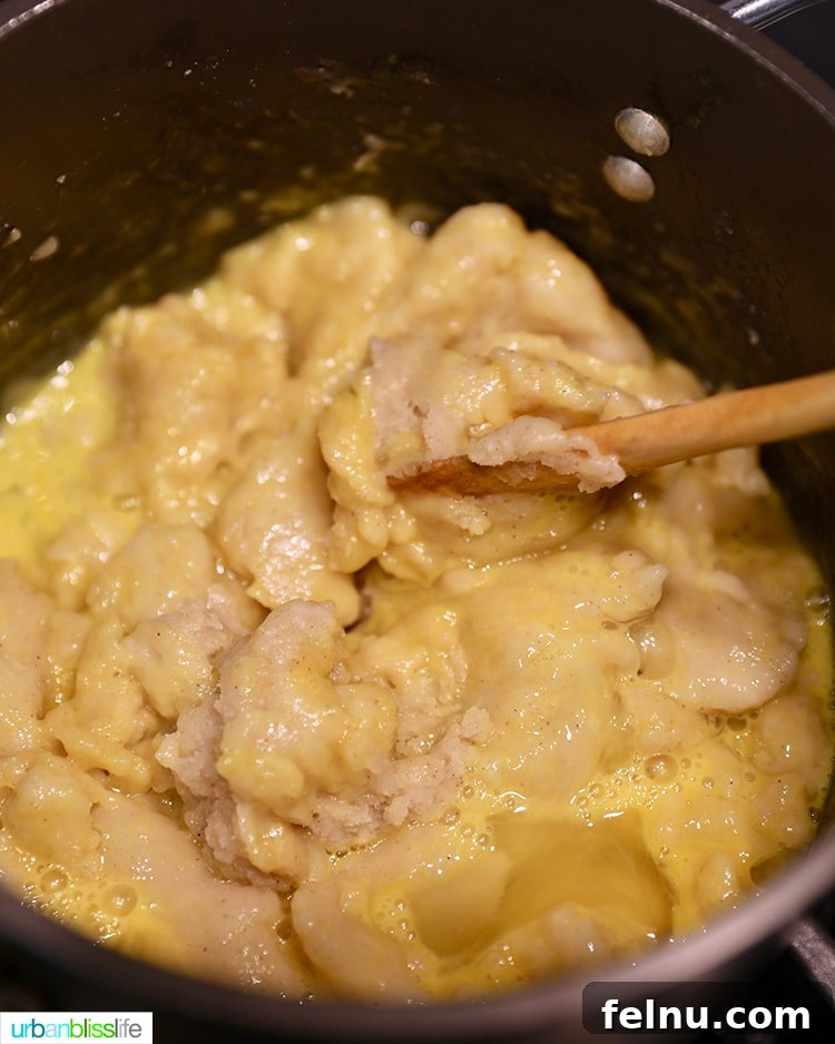 Adding eggs to the prepared churro dough mix.