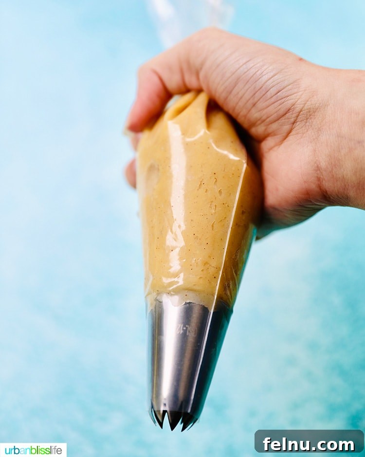 Churro dough loaded into a pastry bag with a star tip.