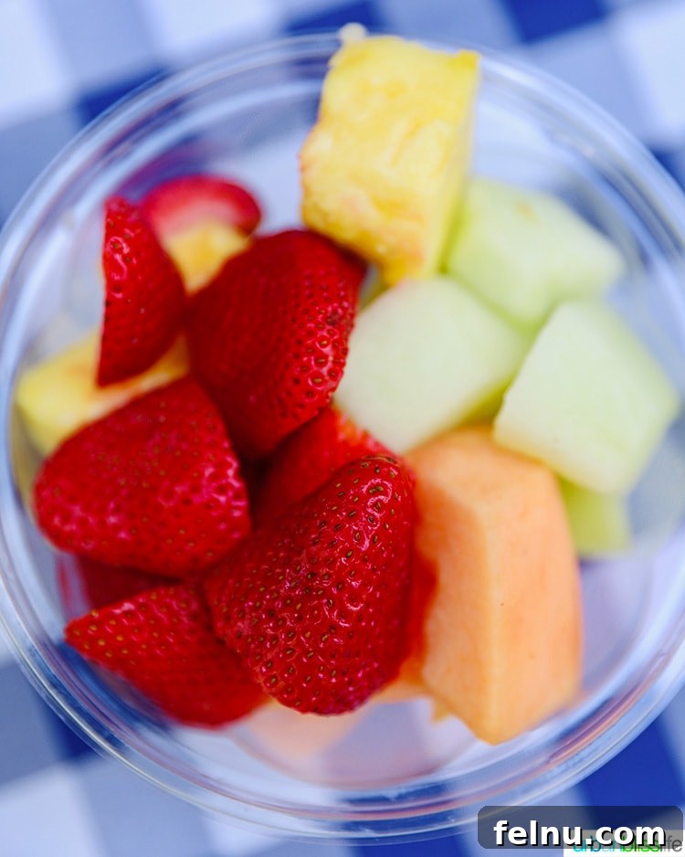 A vibrant and inviting bowl of assorted fresh fruit, perfectly centered and ready to be enjoyed as part of a refreshing summer meal.