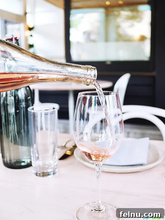 Toast to Summer: 12 Perfect Rosés for National Rosé Day 2 A refreshing glass of rosé wine being poured, capturing the essence of a perfect summer happy hour.