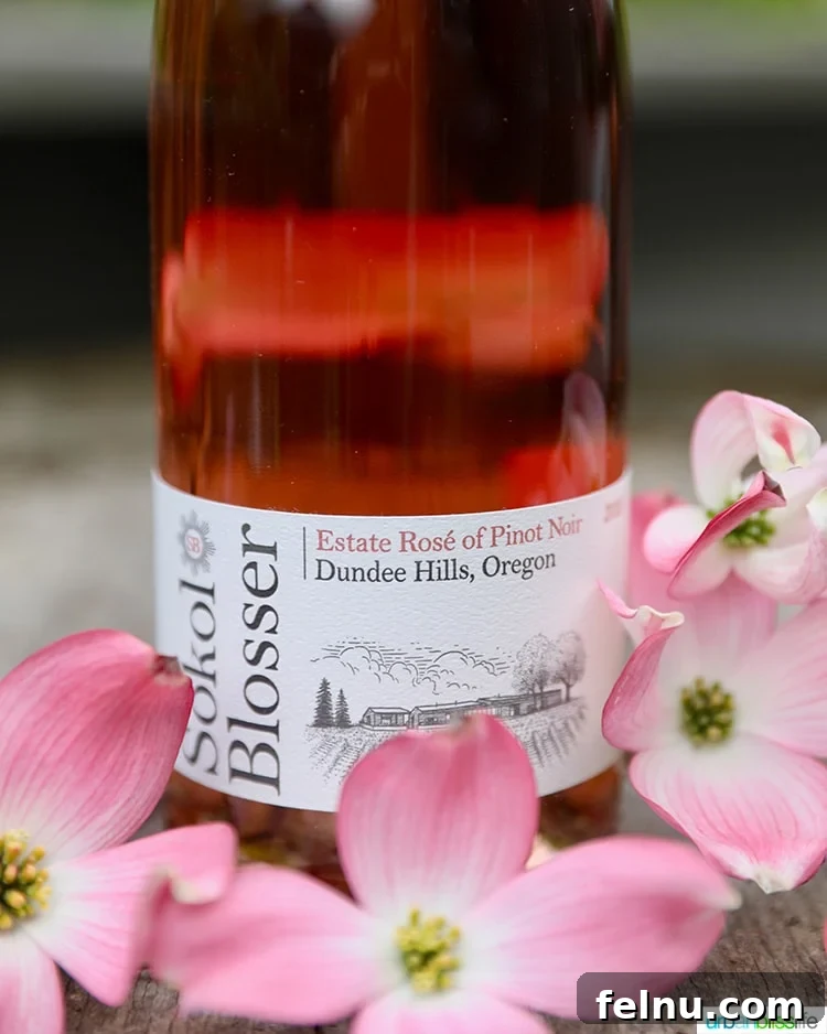 Toast to Summer: 12 Perfect Rosés for National Rosé Day 11 A bottle of 2019 Sokol Blosser Rosé with delicate pink flowers, highlighting the wine's elegance and freshness.