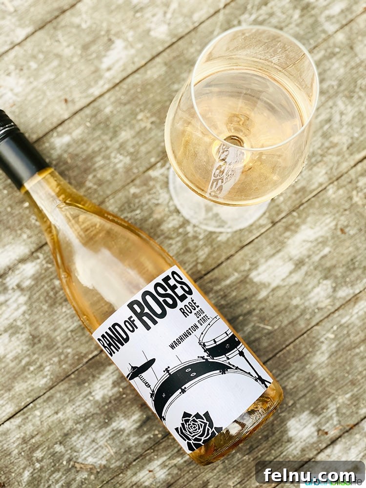 Toast to Summer: 12 Perfect Rosés for National Rosé Day 5 A bottle of Charles Smith Band of Roses rosé wine, alongside a glass filled with the vibrant pink liquid, embodying modern wine style.