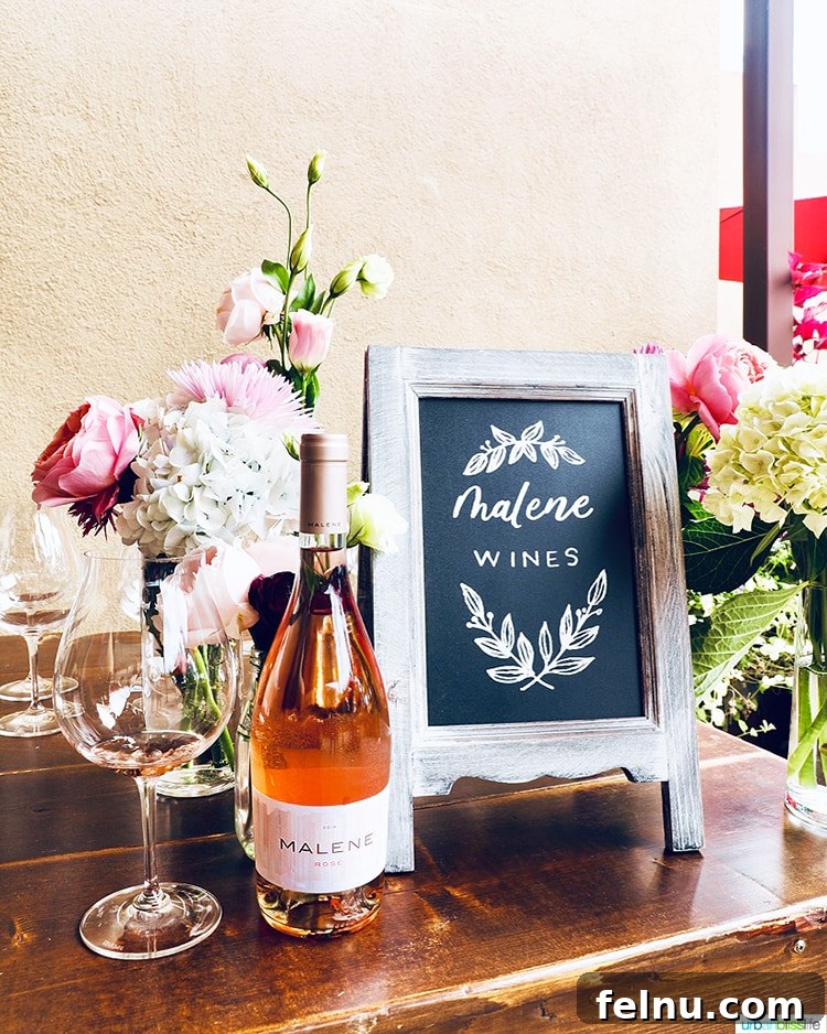 Toast to Summer: 12 Perfect Rosés for National Rosé Day 8 A bottle of Malene Rosé accompanied by fresh flowers and a wine glass, illustrating a perfect setting for a relaxed moment.