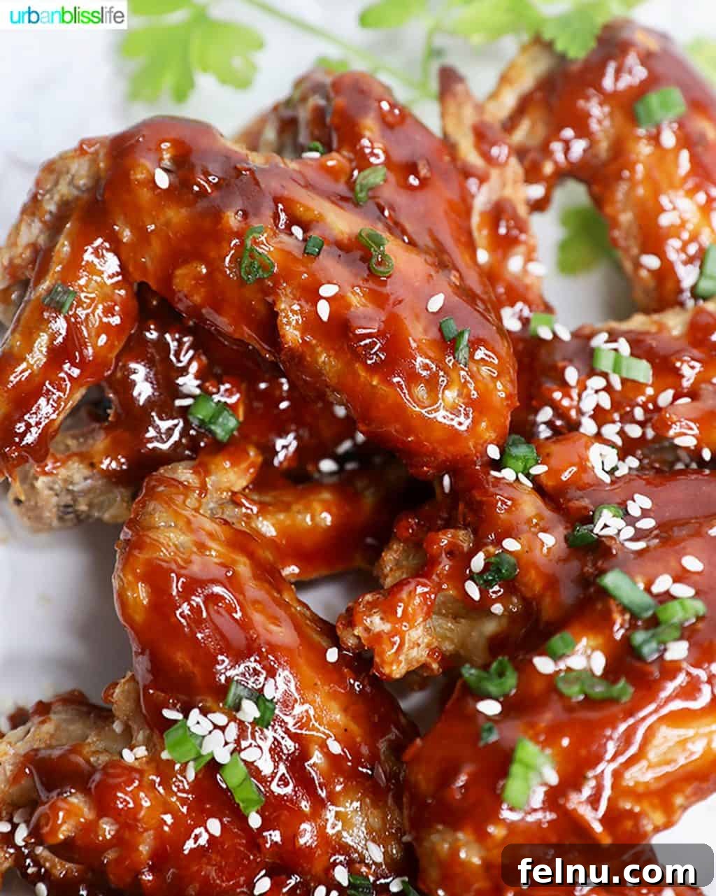 Sticky Teriyaki Air Fryer Wings 4 Air fryer chicken wings being coated in teriyaki sauce, ready to serve.