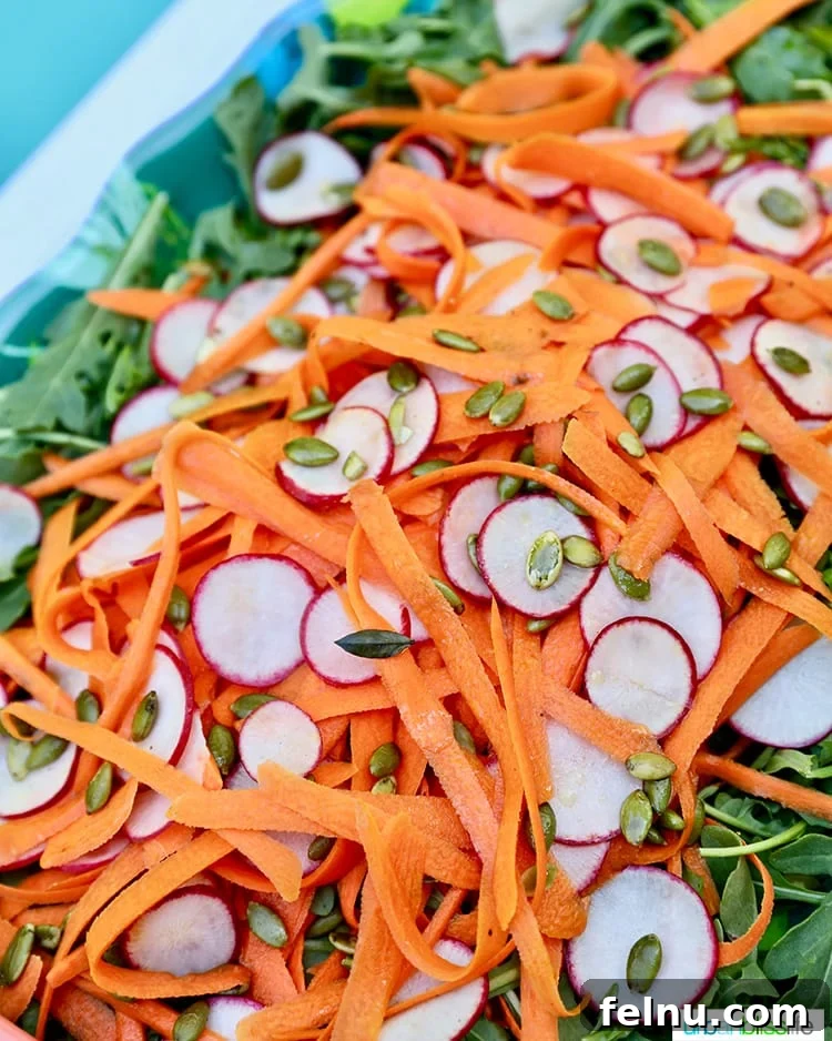 Zesty Radish Carrot Slaw 2 Close-up of a vibrant Radish Carrot Salad with fresh arugula and a light dressing.
