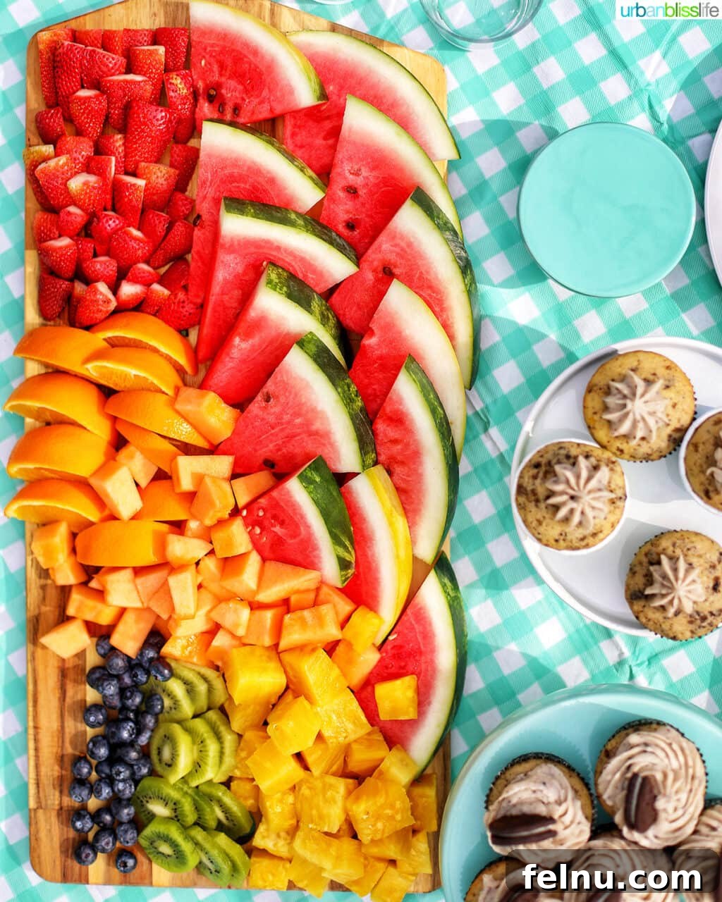 Beat the Heat Dinners 2 Large fruit platter on an aqua checkered tablecloth with side of cupcakes, perfect for a no-cook summer dinner.