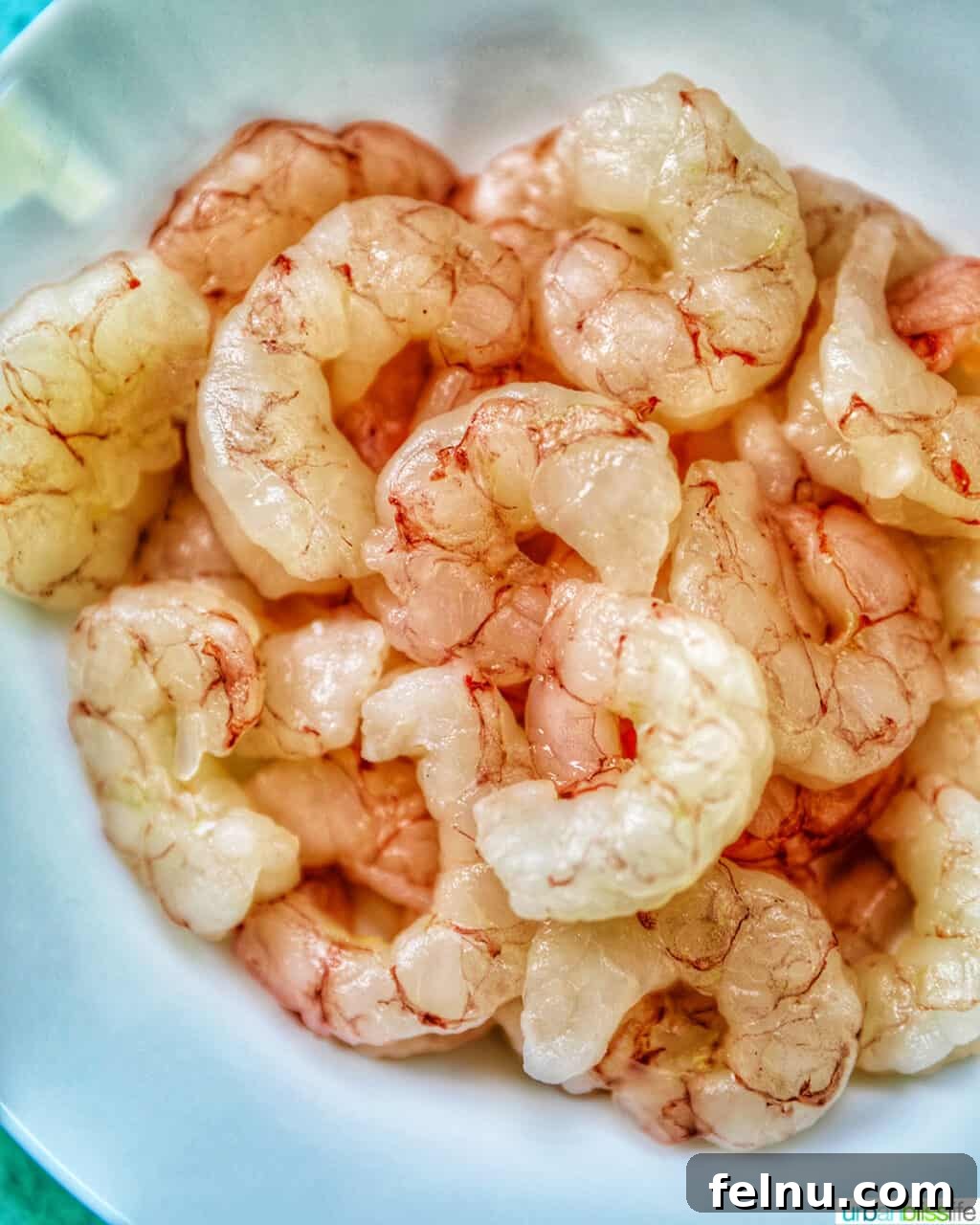 Beat the Heat Dinners 3 Raw shrimp in a white bowl, ready for quick cooking or thawing for cold dishes.