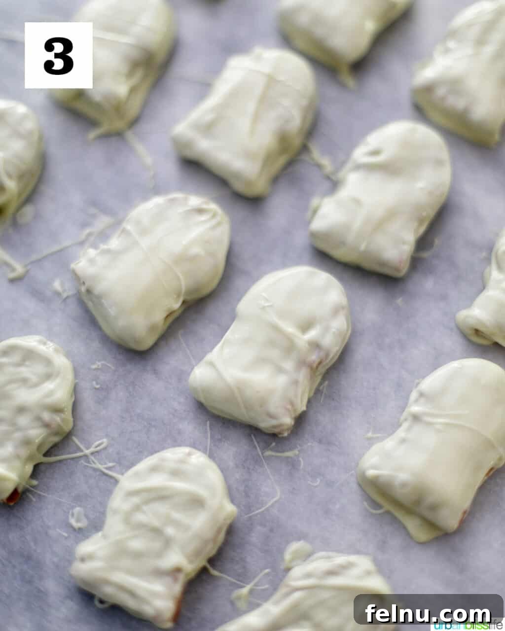 Spooky Nutter Butter Ghosts 7 Nutter Butter cookies dipped in white chocolate on a baking sheet