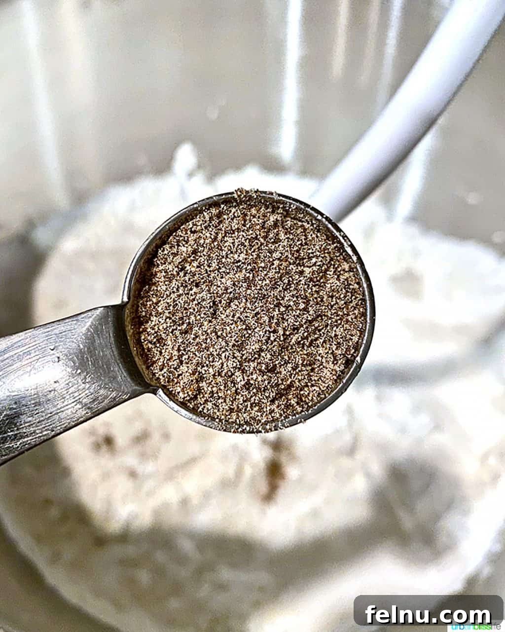 Overnight Orange Spice Rolls 4 A close-up of a teaspoon filled with aromatic ground cardamom.