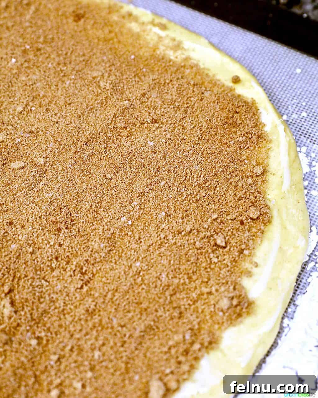 Overnight Orange Spice Rolls 10 The cinnamon sugar filling being generously spread over the prepared dough for orange cinnamon rolls.