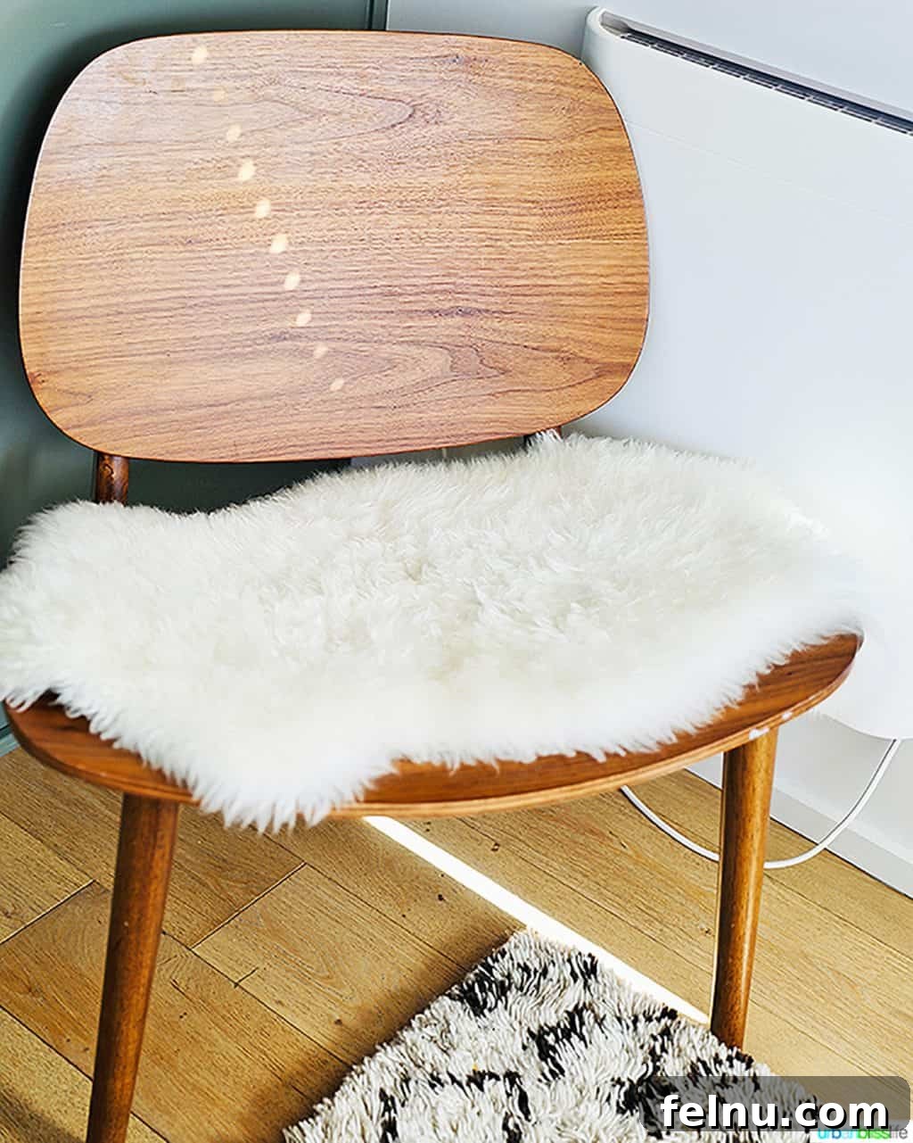 Glamping in Wine Country: Vintages Trailer Resort in Oregon's Willamette Valley 14 A stylish mid-century modern chair adorned with a cozy fuzzy throw blanket, inviting comfort and adding a chic touch to the interior design.