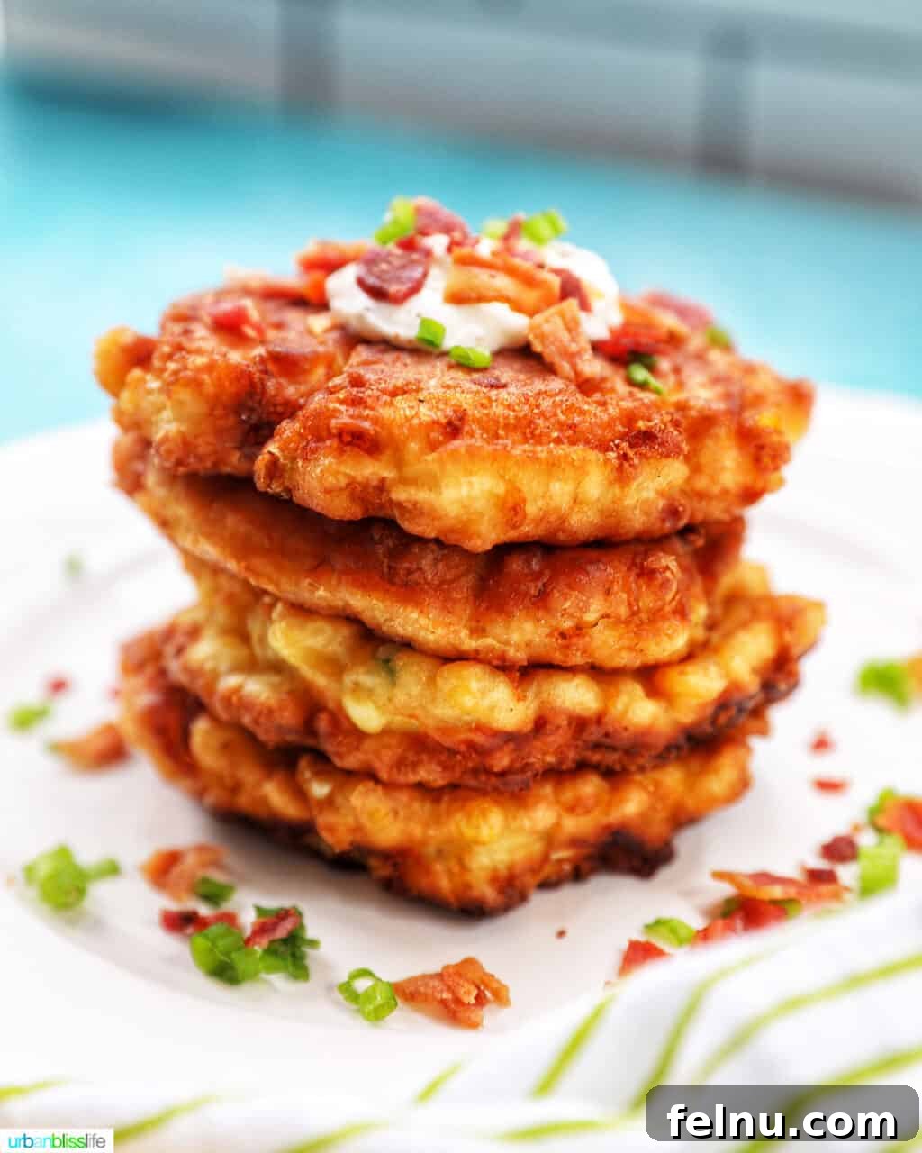 Golden Corn Fritters 2 Stack of golden-brown crispy corn fritters, garnished with fresh herbs, ready to be enjoyed.