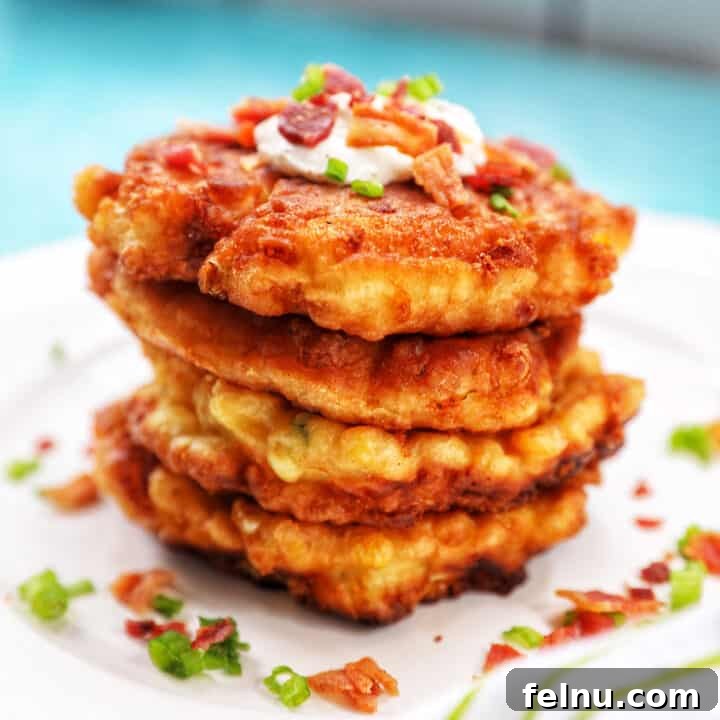 Two golden-brown corn fritters stacked neatly, highlighting their crispy texture.