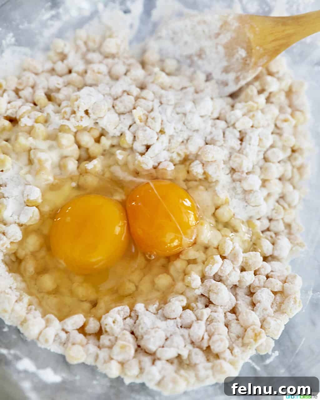 Golden Corn Fritters 4 Adding two egg yolks to the corn fritter batter, an essential step for binding.