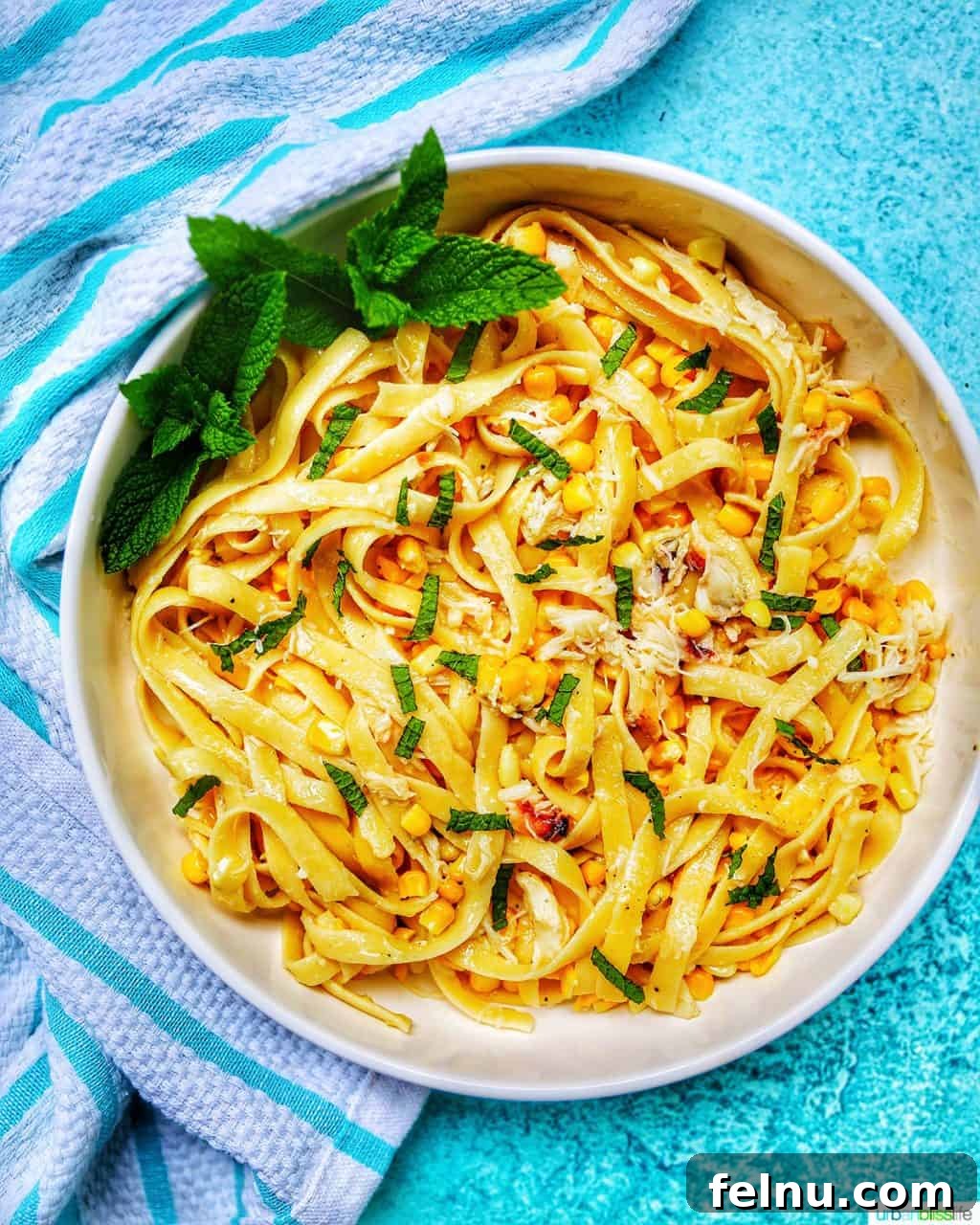 Close-up of crab pasta in a bowl with blue background