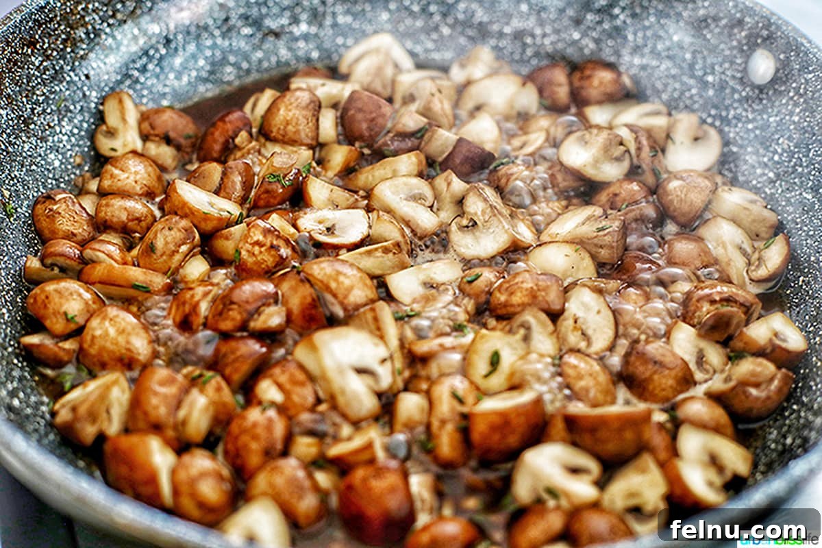 Savory Marsala Mushrooms 10 Close-up of Marsala wine bubbling with mushrooms in a wide pan, creating a delicious reduction