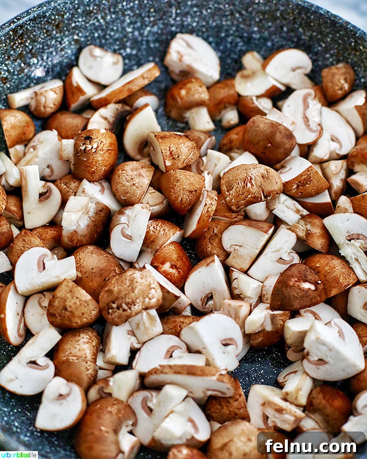 Savory Marsala Mushrooms 6 Quartered mushrooms starting to cook in a hot pan with butter, beginning to soften and release moisture