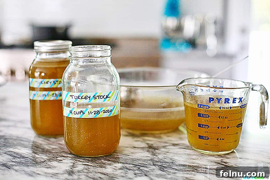 Homemade turkey stock labeled in measuring cup and mason jars