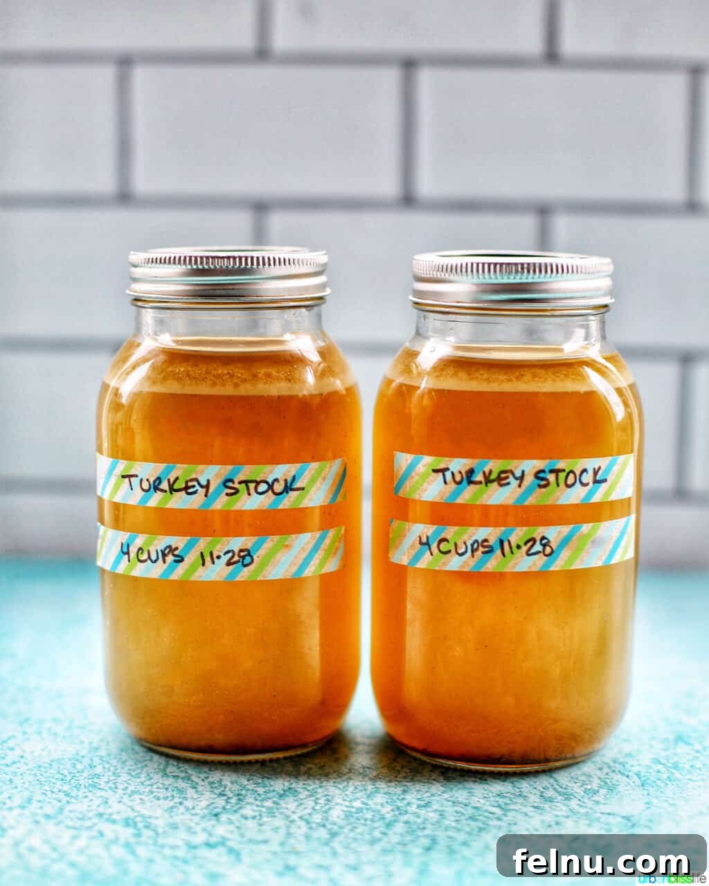 Two mason jars filled with golden homemade turkey stock