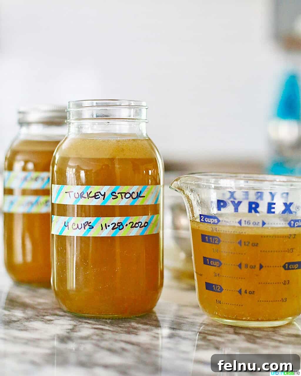 Homemade Turkey Stock in mason jars and pyrex measuring cup