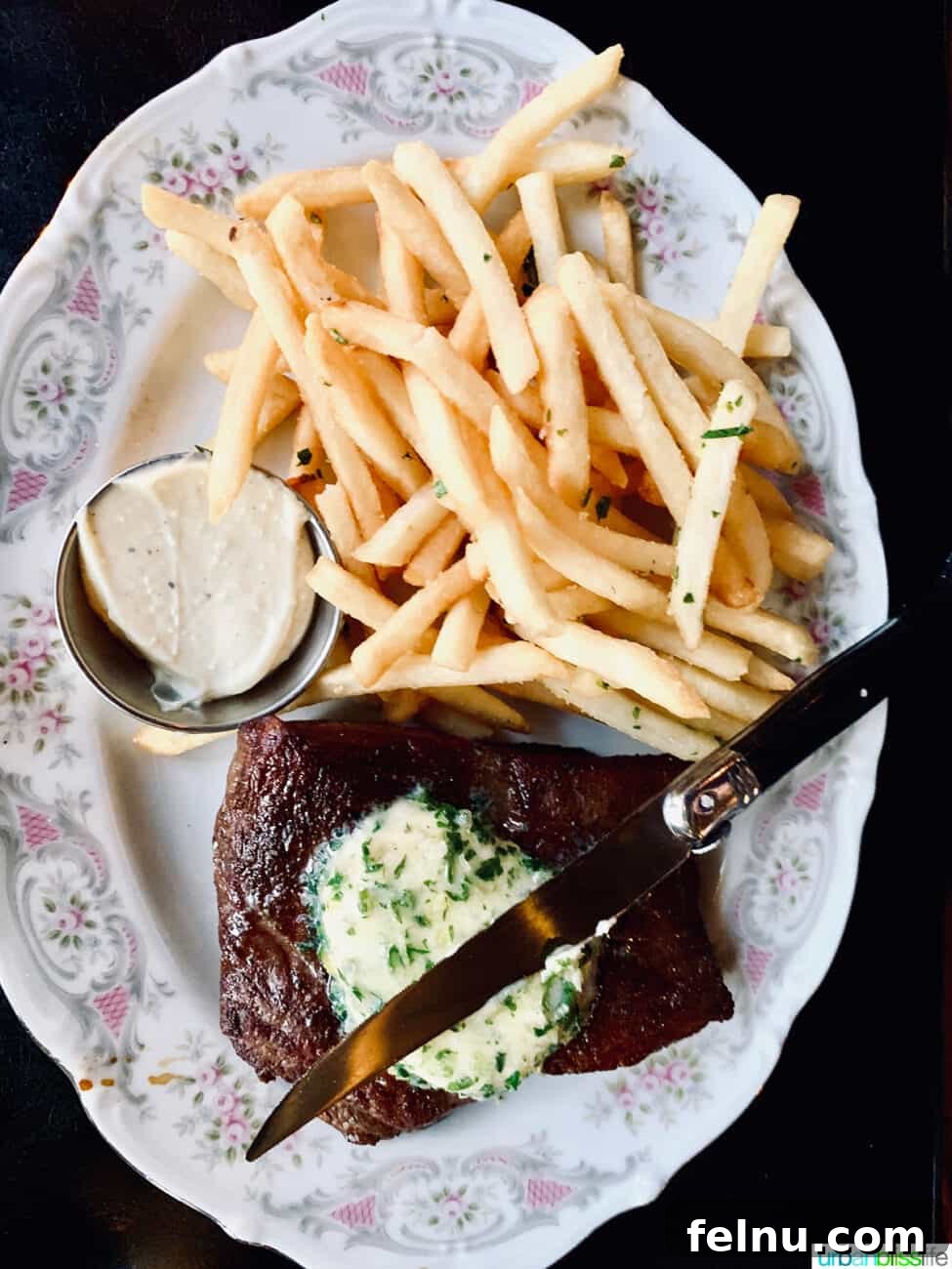 Portland's Top Romantic Dinner Spots 17 Elegant steak frites with a knife and side of butter on a formal china plate at La Moule restaurant in Portland, Oregon.