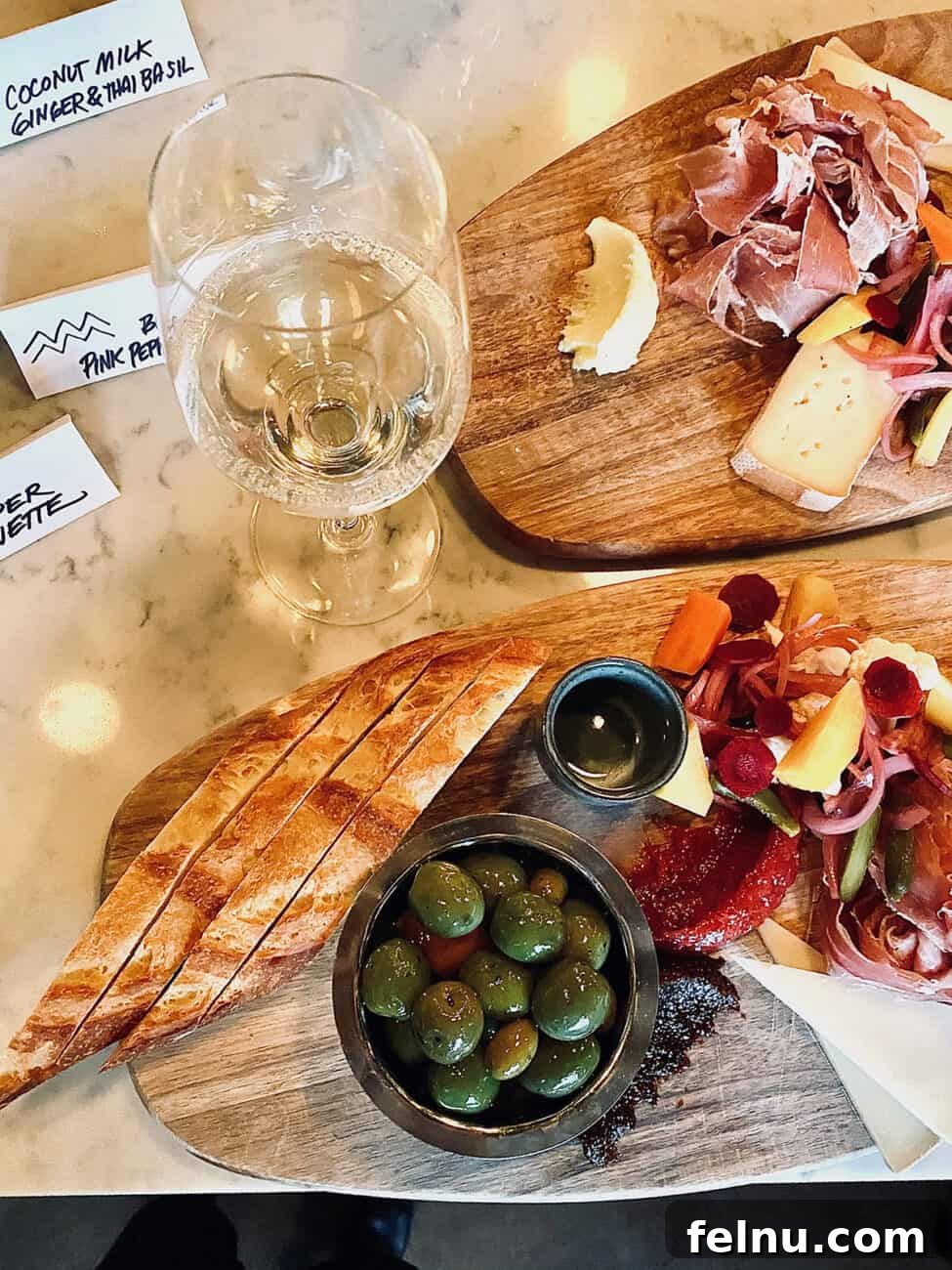 Portland's Top Romantic Dinner Spots 31 Elegant glass of white wine next to artfully arranged charcuterie boards at Normandie restaurant in Portland, Oregon.