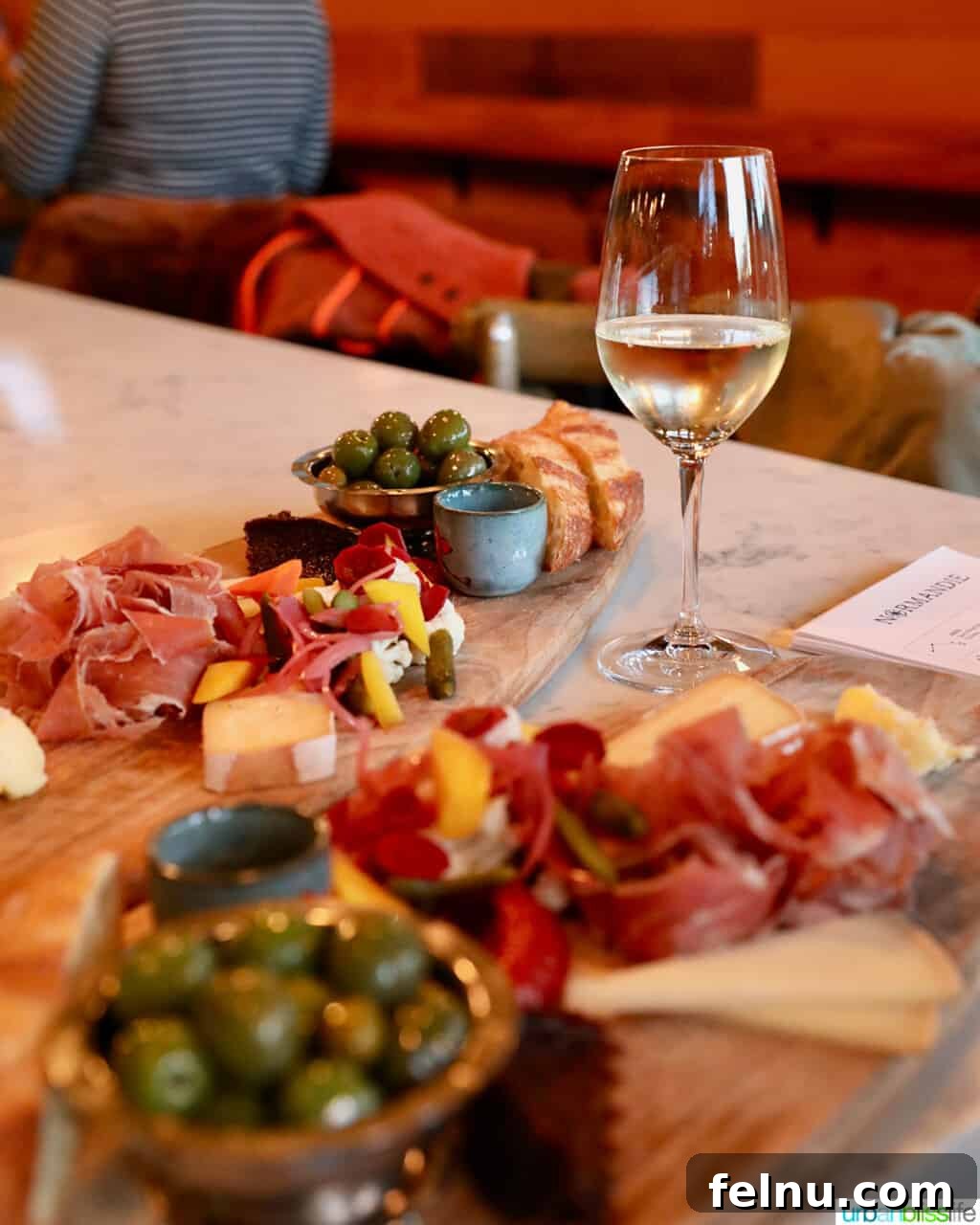 Portland's Top Romantic Dinner Spots 33 Inviting charcuterie boards paired with a glass of white wine at Normandie restaurant in Portland, Oregon.