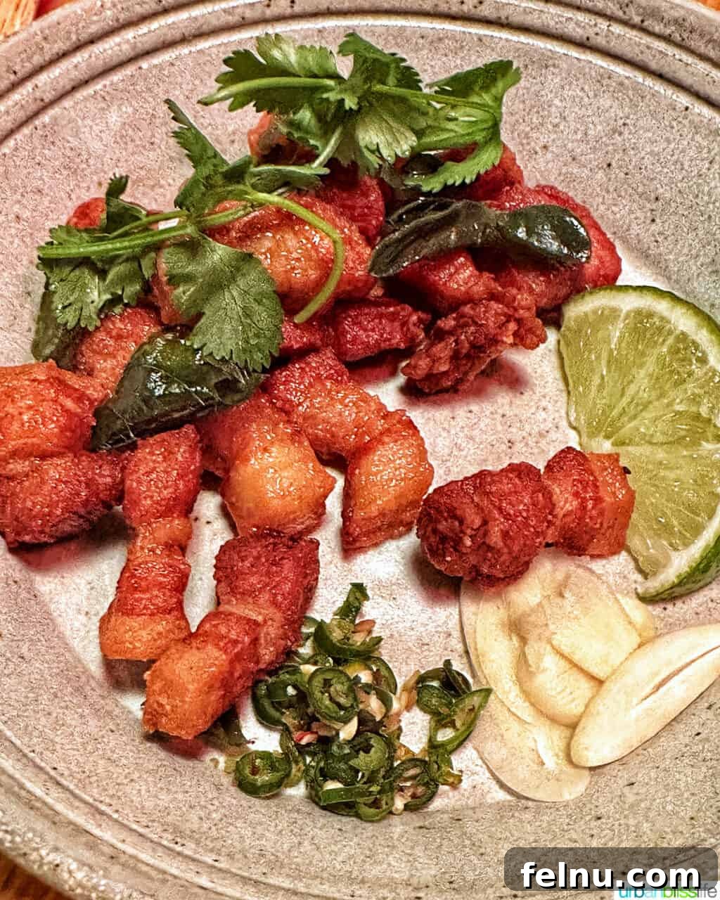 Portland's Top Romantic Dinner Spots 36 Close-up of crispy pork belly bites with lime wedge on a grey plate at Phuket Cafe.