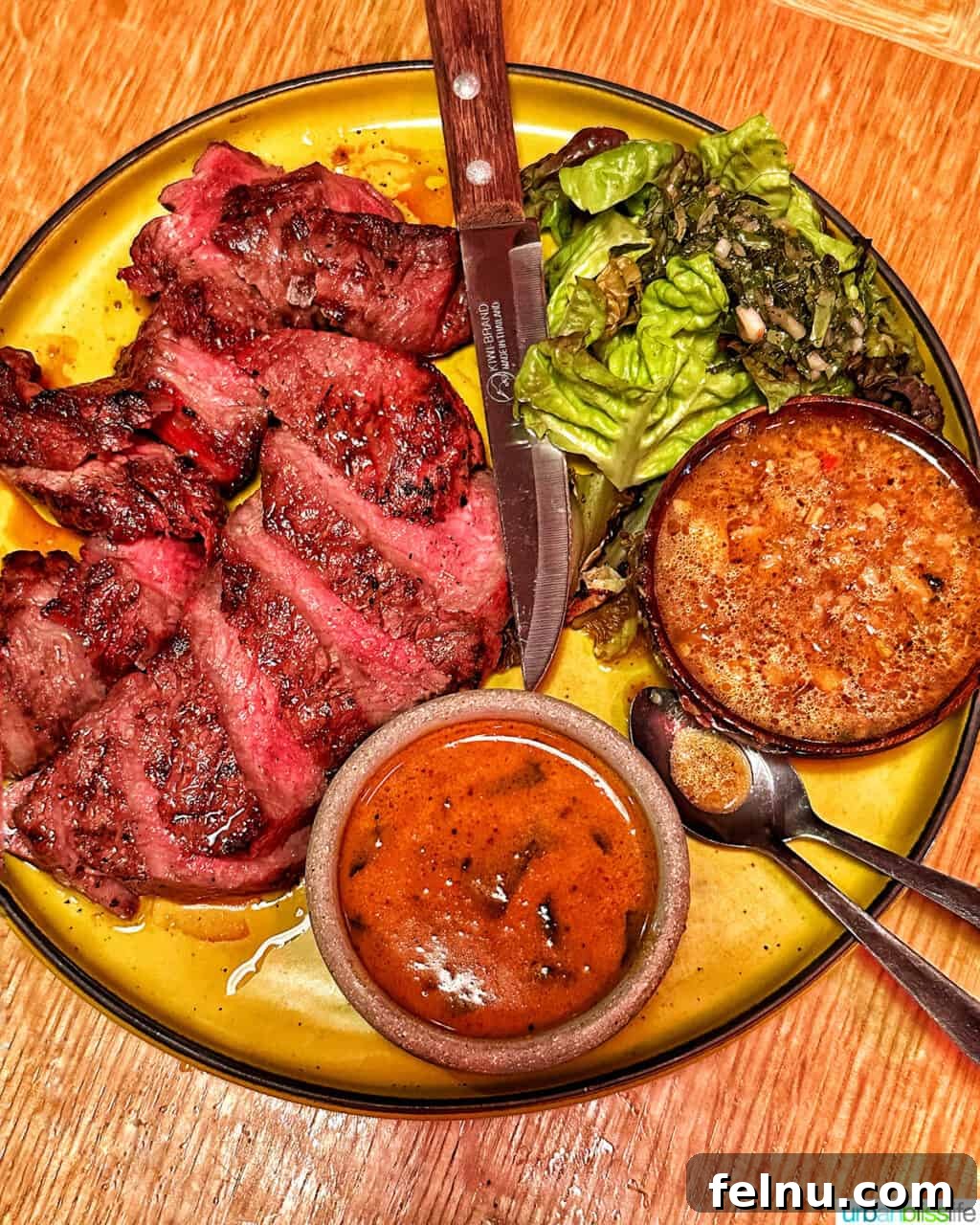 Portland's Top Romantic Dinner Spots 39 Plate of perfectly sliced rib eye steak with accompanying sauces on a wood table at Phuket Cafe.