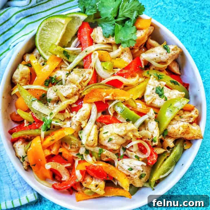 Sizzling Sheet Pan Chicken Fajitas 14 Sheet pan chicken fajitas with peppers and a lime in a bowl, ready to be served and enjoyed.