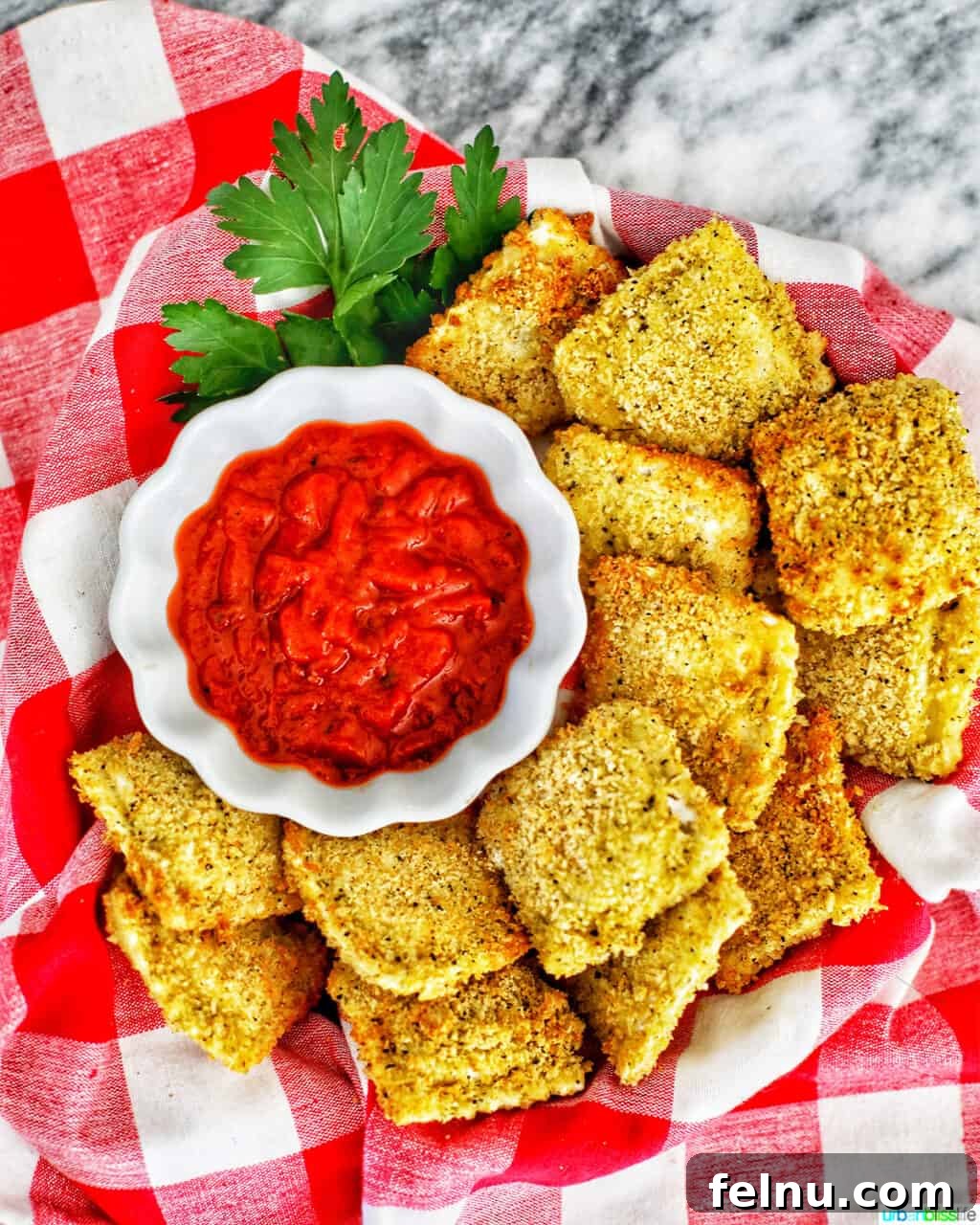 Air Fryer Ravioli Bites 3 Close-up of Air Fryer Ravioli with a vibrant red dipping sauce.
