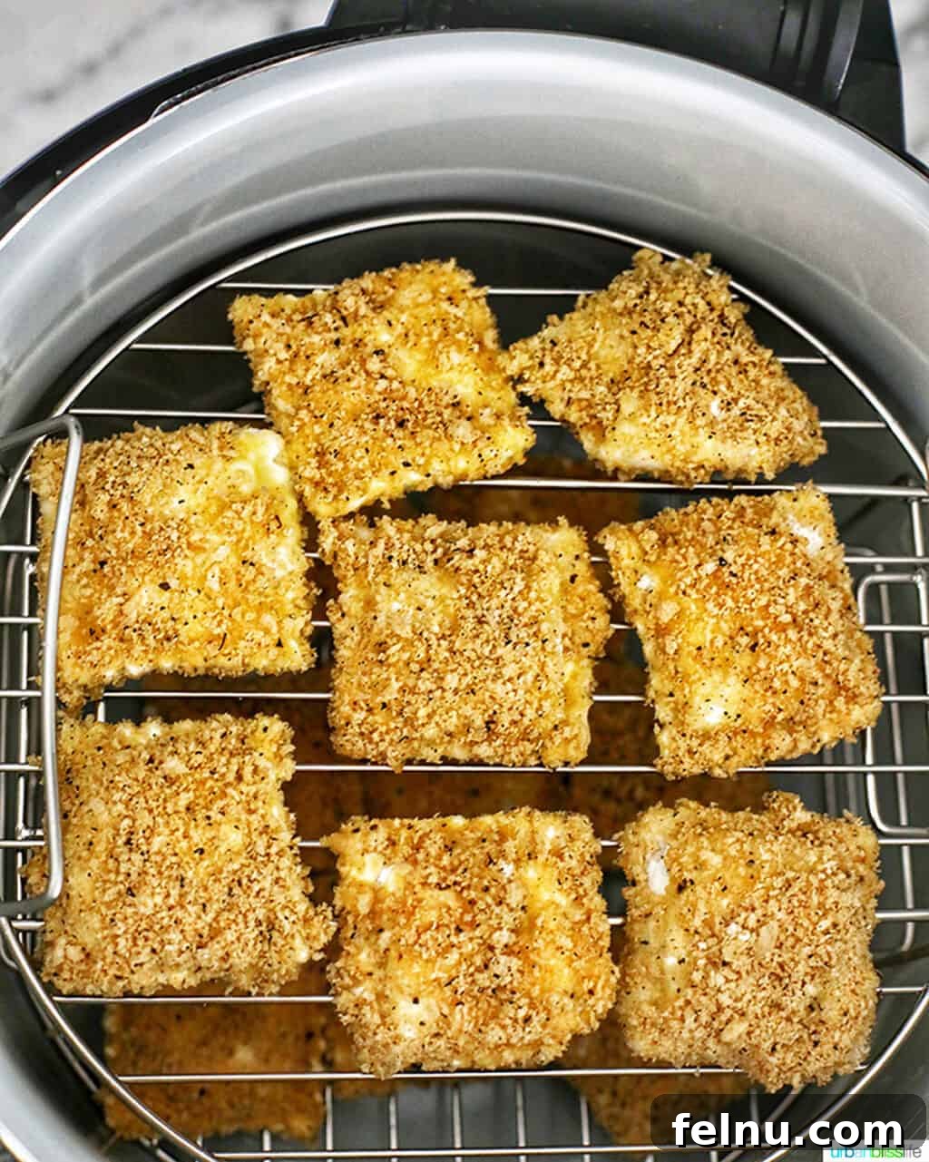 Air Fryer Ravioli Bites 6 Placing the breaded ravioli on Ninja Foodi racks ready for air frying.